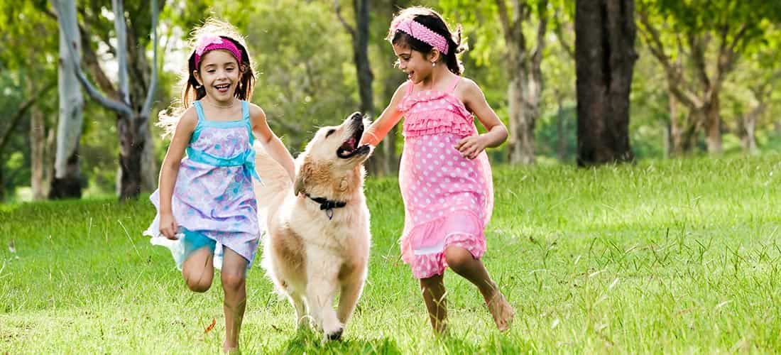 Two girls running with dog