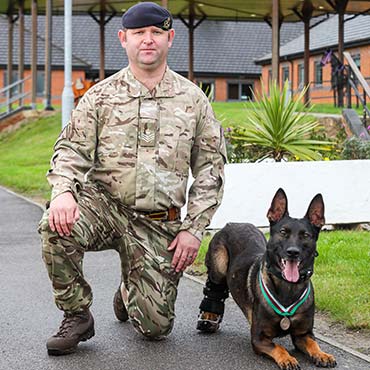 Kuno with his handler and his medal