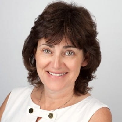 A photo of Elaine Deste smiling at the camera in front of a white background