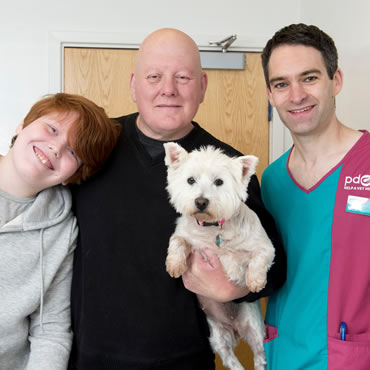Sugar with her family and a PDSA Vet