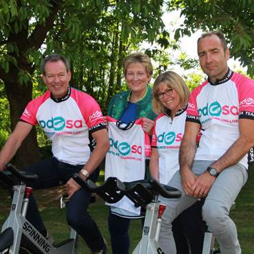 PDSA Directors in their fundraising shirts sitting on the exercise bikes they'll use in their fundraising challenge