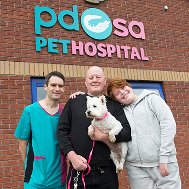 Sugar the Westie with her owners and a vet
