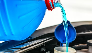 Photo of screen wash being filled up in a car